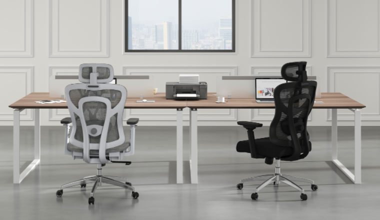 there are 2 office chairs in front of the desk, one is grey and another one is black color