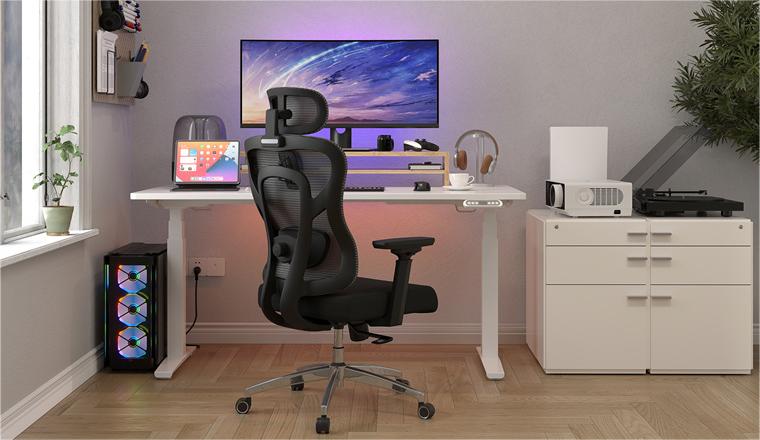 an black office chair with mesh backrest and a sponge seat, with a stanidng desk and a computer on the desk. 