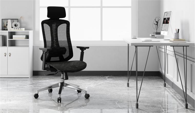 an all black mesh office chair, with a white desk